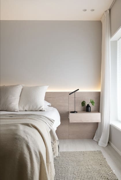 Respaldo de cama diseñado por el estudio en melamina simil madera. “No queríamos nada llamativo porque la casa ya tiene un piso de madera en el hall muy fuerte. Acá tratamos de ir por una paleta en tonos blancos y beiges”. Textiles (Mercer Studio) e iluminación (Lumishop).