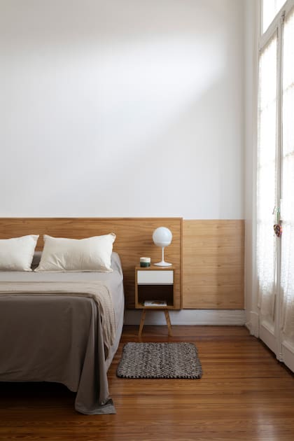 Respaldo de madera (Javier Ravelo). Mesas de luz (Traë). Veladores ‘Copa’ (Glitter). Cubrecama (Calm). Vela en envase de cerámica artesanal (Bohemia Velas). Pie de cama tejida (Luna Deco).