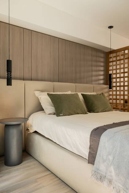 Respaldo y base de cama en pana crudo y mesas de luz en madera paraíso teñida en gris oscuro (Estudio Aldo). Textiles (Philomena Home) y luminarias torneadas (Dimm).