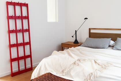 Respaldo y mesas de luz (Marini Estudio). Banco y perchero (La Base Studio). El paño fijo de vidrio lleva más luz hacia el baño que está a continuación.