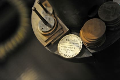 Una vieja foto cedida por el Parlamento muestra antiguos centavos que se usaban para mantener el péndulo del reloj funcionando correctamente