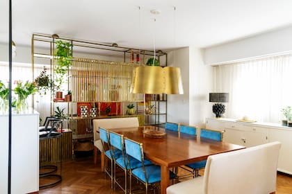 Retapizar con pana turquesa las sillas de bronce antiguas le dio una nueva vida al comedor.