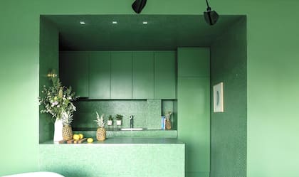 Revestida en venecitas, la cocina integrada se abre como un espacio profundo y brillante. Los muebles se laquearon para imitar su color, y luego llegó el desafío de encontrar la pintura que no rompiera el hechizo en el resto de las paredes.