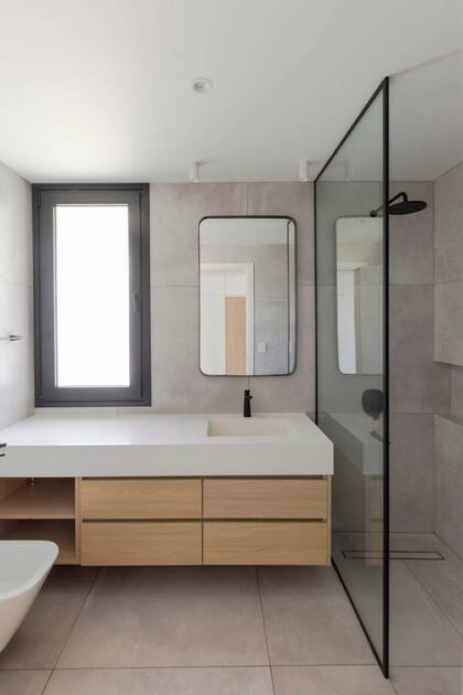 Revestimiento completo de Nord Ris (Portobello). Sanitarios de Roca. Grifería 'Aromo' (Fv). Mueble en melamina 'Roble Kendal' (Egger).