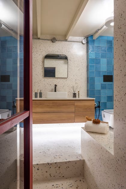 Revestimiento de terrazo (Pimux) y cerámico ‘Tabarca’ (Dune), mueble (Mario Naschimbene), mesada en ‘Purastone’, bacha (Ideal) y grifería (FV). Espejo con marco de hierro (Antiguo Vagón Deco), dispenser (Philippa Deco Boutique), cepillos de dientes (GoBlue) y difusor (Bohemia). Sobre la toalla (Luna Deco), cepillos (Orbol).