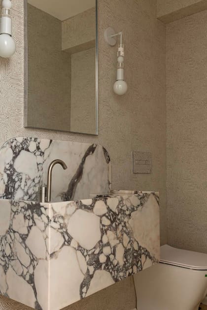 Revestimiento entelado (De Levie), mesada en Calacata Viola (Marmolería De Stefano) con pileta exenta y monocomando de la marca italiana 'Fantini' (Folk). Apliques 'Ábaco' (Estudio Molé).