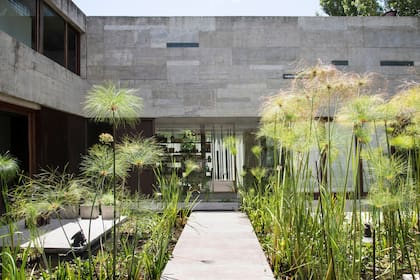 Un estanque participativo que da la bienvenida y es paso obligado desde la calle a la puerta de ingreso en la vivienda.