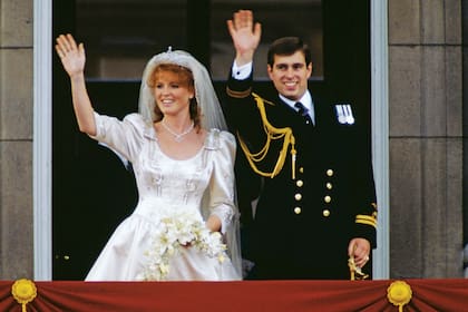 Andrés Mountbatten-Windsor y
Sarah Ferguson saludan desde el balcón de Buckingham, en el día de su soñada boda, el 23 de julio de 1986