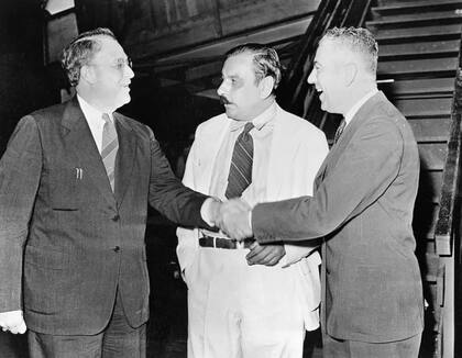 Rexford Tugwell (derecha) da la mano a su predecesor Guy Jacob Swope. En el medio, Luis Muñoz Marín, quien en ese momento era presidente del Senado de la isla. (GETTY IMAGES)