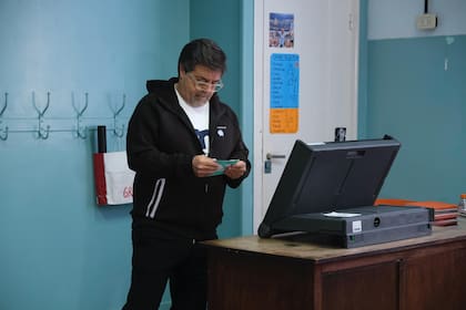 Ricardo Caruso Lombardi pliega la boleta antes de cerrarla, en la jornada electoral porteña
