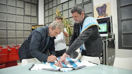 Ricardo Darín firma una camiseta del seleccionado campeón después de grabar con su voz el relato del documental sobre el triunfo argentino en Qatar 2022 