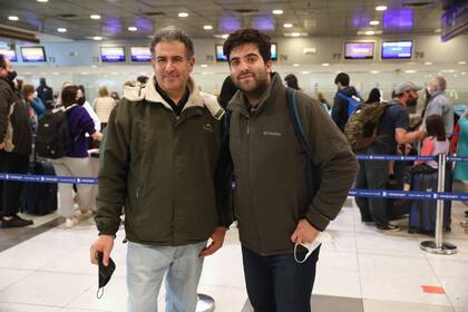 Ricardo e Ignacio esperan a su madre mientras hace el check-in para viajar a Suiza