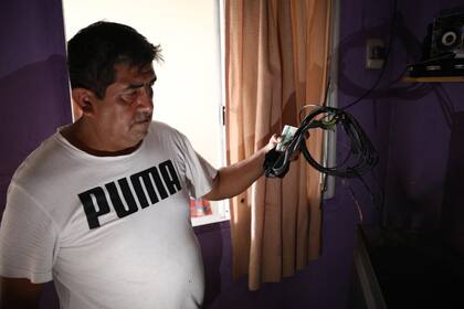Ricardo Yapura muestra el cable de internet incendiado tras el cortocircuito con la línea de alta tensión de Edenor