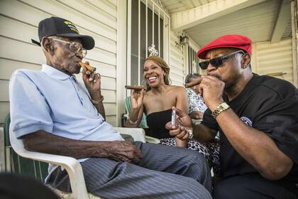 Richard Overton, a la izquierda, fuma un cigarro con algunos amigos del vecindario Donna Shorts, en el centro y Martin Wilford el domingo 3 de mayo de 2015 en Austin, Texas.