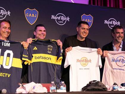 Riquelme exhibe una camiseta con el tradicional sello de Hard Rock Café y el nombre "Boca Juniors", durante la firma del convenio, en junio pasado