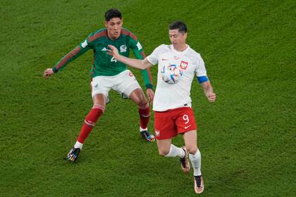 Robert Lewandowski intenta dominar el balón frente a Edson Álvarez