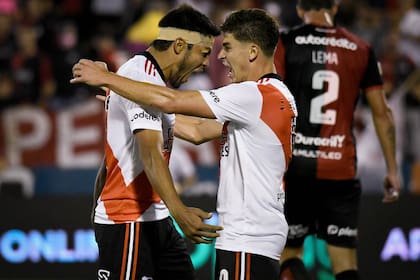 Robert Rojas, con la cabeza vendada, festeja con Julián Álvarez un gol a Newell's