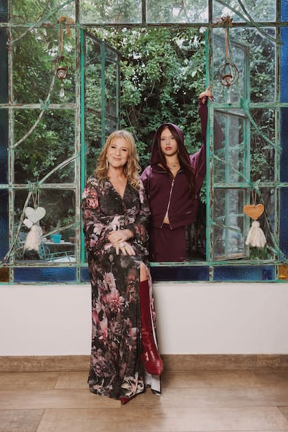 Rodeadas de plantas y flores, madre e hija posan en el PH antiguo que comparten
