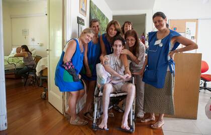 Rodeado de cariño: uno huésped del hospice San Camilo, junto a un grupo de voluntarias.