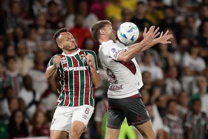 Rodrigo Castillo aguanta la carga del lateral René; en los minutos finales del primer tiempo, Lanús tomó oxígeno tras el asedio de Fluminense