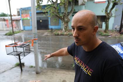 Rodrigo Iglesias, empleado bancario y expolicía, junto al poste que generó la descarga eléctrica, ubicado en la puerta de su casa