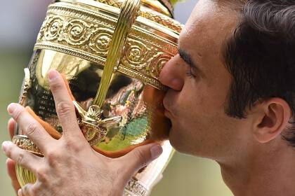 Roger Federer besa el trofeo después de vencer a Marin Cilic de Croacia en su partido final individual masculino, durante la presentación del último día del Campeonato de Wimbledon 2017 en el All England Lawn Tennis, el 16 de julio de 2017