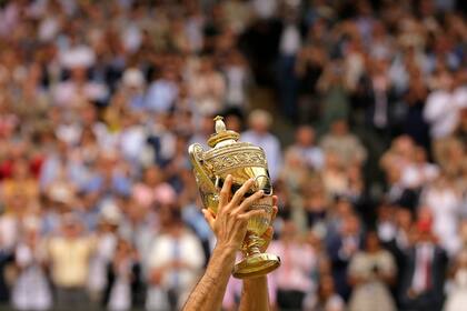 Roger Federer celebra con el trofeo después de vencer al croata Marin Cilic en el partido final individual masculino el día trece en el Campeonato de Tenis de Wimbledon, en Londres, el 16 de julio de 2017