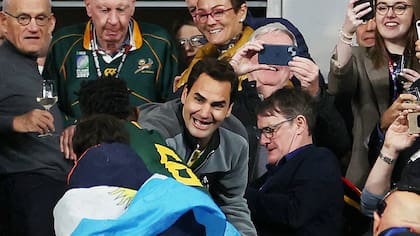 Roger Federer felicita a Siya Kolisi, el capitán de Sudáfrica, campeón en Francia 2023, ante un espectador argentino en el Stade de France; la cercanía para el gran público es otra causa que favorece a Europa por sobre Sudamérica en la organización de los mundiales.