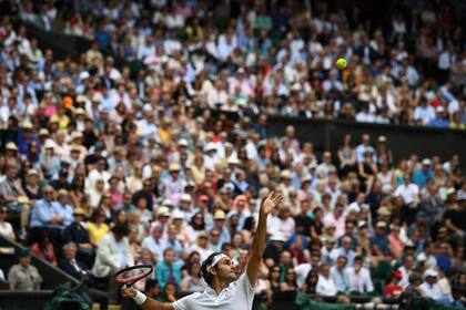 Roger Federer sirve a Milos Raonic de Canadá durante el partido de semifinales masculino en el duodécimo día del Campeonato de Wimbledon en el All England Lawn Tennis Club, en Londres, el 8 de julio de 2016