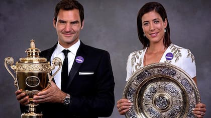 Roger Federer y Garbiñe Muguruza con los trofeos de campeones