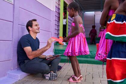 Roger Federer y una de las niñas que son asistidas por su fundación benéfica en Windhoek, Namibia