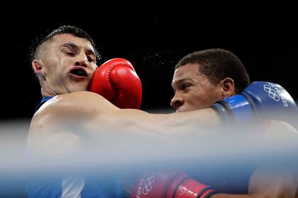 Rohan Polanco Emiliano, de República Dominicana, derecha, golpea la cara de Bobo-Usmon Baturov, de Uzbekistán, durante su combate de boxeo preliminar de peso welter (69 kg) en los Juegos Olímpicos de Verano de 2020, el martes 27 de julio de 2021, en Tokio. , Japón