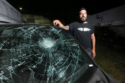 Rojas junto al Chevrolet Corsa con el cristal roto por la acción del taxista Rímolo