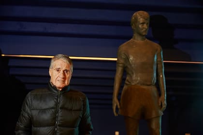 Rojitas posa junto a su estatua, ubicada en los pasillos de La Bombonera