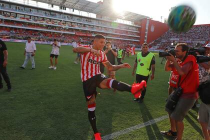Rojo patea una pelota, vestido como si fuese a jugar