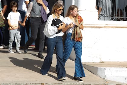 Romina Bianchi, la viuda de Rafa, abraza el casco de polo de su marido y contiene a su hija mayor, Juana, a la salida del cementerio.