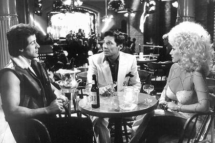 Ron Leibman junto a Sylvester Stallone y Dolly Parton en una escena de la película Rhinestone