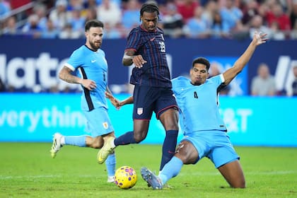 Ronald Araújo intenta frenar a Haji Wright; detrás observa Nández (Photo by Rich Storry / GETTY IMAGES NORTH AMERICA / Getty Images via AFP)