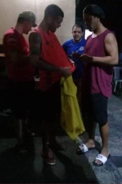 Ronaldinho firmando la camiseta de un preso. Fuente: Twitter