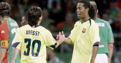 Ronaldinho saluda a Messi, de espalda, tras el penal que le cometió Schulz; el argentino jugó poco, pero fue efectivo