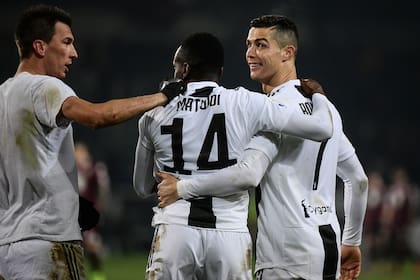 Ronaldo sonríe abrazado a Matuidi, mientras Mandzukic se acerca.