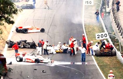 Ronnie Peterson, ya fuera del Lotus, es asistido en el piso, junto a otros pílotos; detrás, el Lotus negro N° 6