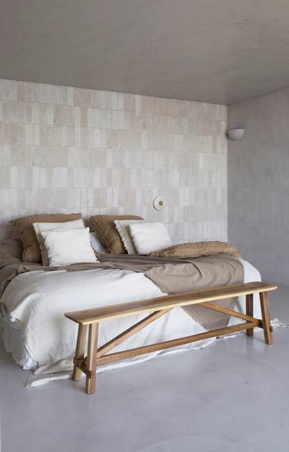 Ropa de cama (Casa Tarlo), pie de cama (Compañía Nativa), banco de madera recuperada (Estudio Trae). Apliques de alabastro (Dimm Iluminación).