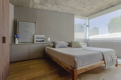 Ropa de cama (Klimt House). Almohadón tejido (Claudia Adorno). Sobre el respaldo de cama, obra grande (Michelle Dabul) y fotografía de las playas de Uruguay (Felicitas Carneiro).