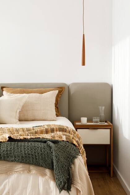 Ropa de cama (Lote propio), lámparas colgantes (Dimm), mesas de luz (Mínima Huella) y vela en envase de vidrio (Bohemia Velas).