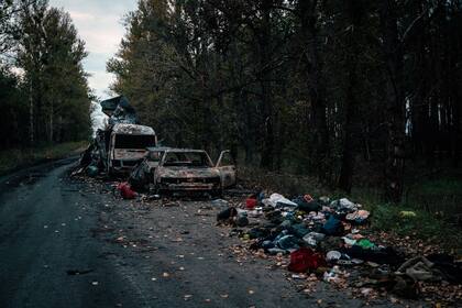 Ropa y otras pertenencias de soldados rusos, junto a vehículos quemados en la recién liberada Lyman