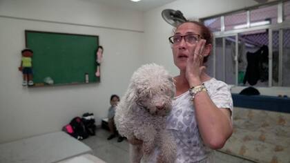 Roselaine da Silva llora al recordar a sus dos gatos que se quedaron en el techo de su casa.