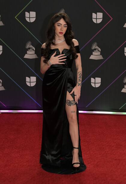 Nicki Nicole, otra de las artistas argentinas que marcaron presencia en la entrega de los Latin Grammy, eligió un vestido negro al cuerpo e importante tajo