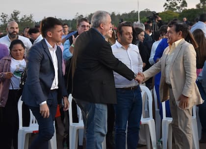 Rovira saluda a Hugo Passalacqua ante la mirada de Oscar Herrera Ahuad, el actual mandatario misionero