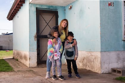 Roxana junto a sus hijos, Alma y Tian, frente a su casa en Virrey del Pino